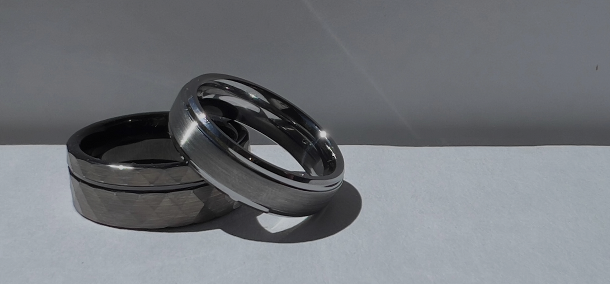 Two dark metal rings on a grey surface