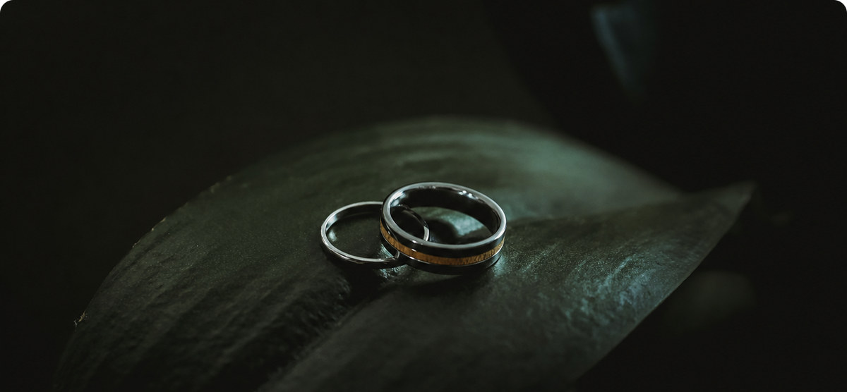 Two premium rings displayed on a dark stone surface